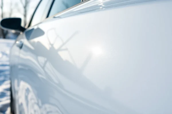 PPF winter road salt protection showcased on a car in a snowy environment, emphasizing durability and gloss.